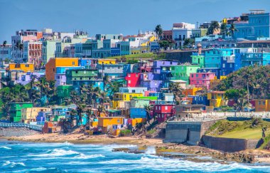 San Juan, Porto Riko 'daki plaja bakan tepe boyunca renkli evler var.