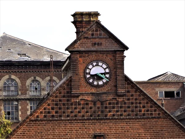 Derelict victorian factory with broken old clock.