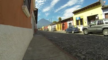 Antigua, Sacatepquez Guatemala, 22 Şubat 2020. Sabahın erken saatlerinde Antigua, Guatemala 'da insanlar, arabalar, trafik, güneş ve arka planda bir yanardağ..