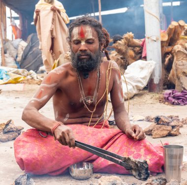 Prayagraj, Uttar Pradesh, Hindistan - Şubat 2019: Hint naga sadhu Hindu ayinine hazırlanıyor - Kumbh Mela Fair.