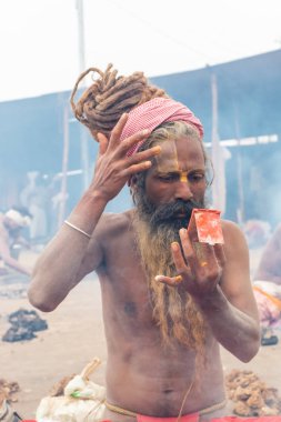 Prayagraj, Uttar Pradesh, Hindistan - Şubat 2019: Hint naga sadhu Hindu ayinine hazırlanıyor - Kumbh Mela Fair.