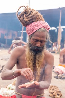 Prayagraj, Uttar Pradesh, Hindistan - Şubat 2019: Hint naga sadhu Hindu ayinine hazırlanıyor - Kumbh Mela Fair.