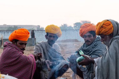 Pushkar, Rajasthan / India - November 2019 : Portrait of rajasthani camel owner/trader in colorful turban and white dress with big mustache participating in camel trading fair