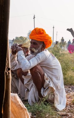Pushkar, Rajasthan / India - November 2019 : Portrait of rajasthani camel owner/trader in colorful turban and white dress with big mustache participating in camel trading fair
