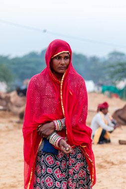 Pushkar, Rajasthan / India - November 2019 : Portrait of young indian woman in traditional rajasthani dressing  with makeup to attract tourist in the fair ground