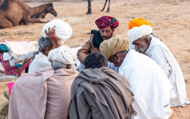 Pushkar, Rajasthan / India - November 2019 : Portrait of rajasthani camel owner/trader in colorful turban and white dress with big mustache participating in camel trading fair