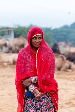 Pushkar, Rajasthan / India - November 2019 : Portrait of young indian woman in traditional rajasthani dressing  with makeup to attract tourist in the fair ground
