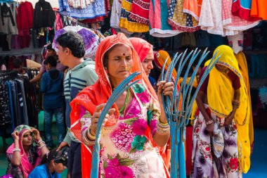 Pushkar, Rajasthan / India - November 2019 : Portrait of young indian woman in traditional rajasthani dressing  with makeup to attract tourist in the fair ground