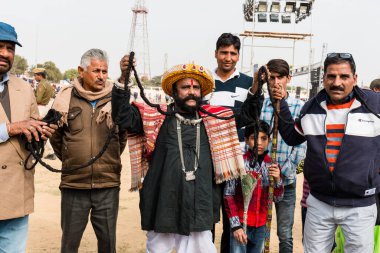 Bikaner, Rajasthan / India - January 2019 : Portrait of rajasthani people  of bikaner in traditional dress and jewelry with long mustache and beard participating in bikaner camel festival