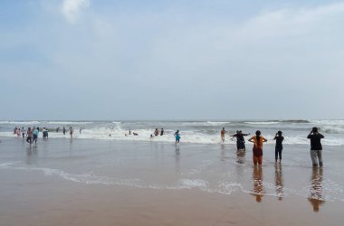 Turistler Odisha 'daki kumsalın ve iklimin tadını çıkarıyorlar.