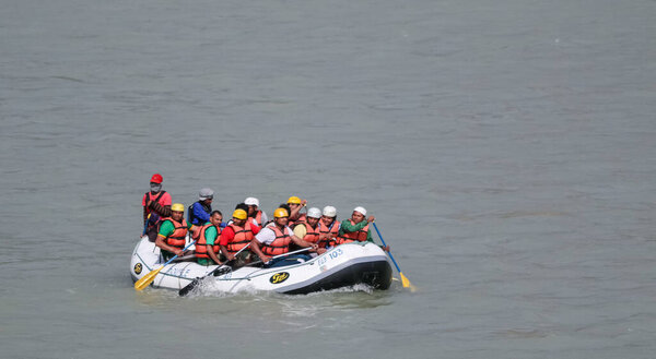 Rishikesh, Uttarakhand / India - Feb 2020 : Tourists from across the world enjoying river rafting water sport in the river ganges at rishikesh