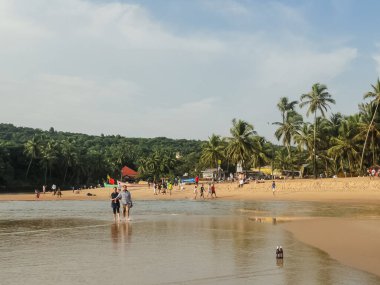 Karamsar gökyüzü ve turistlerle dolu Goa plajlarının manzarası