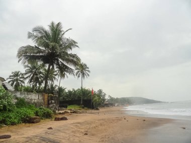 Karamsar gökyüzü ve turistlerle dolu Goa plajlarının manzarası