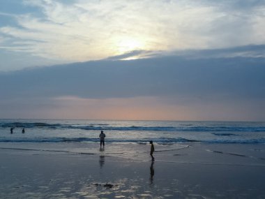 Karamsar gökyüzü ve turistlerle dolu Goa plajlarının manzarası