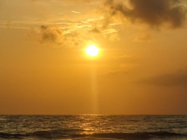 Goa sahillerinde, karamsar gökyüzü ve turistlerle birlikte Arap denizlerinde gün batımı manzarası