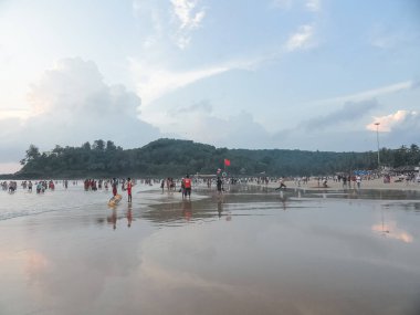 Karamsar gökyüzü ve turistlerle dolu Goa plajlarının manzarası
