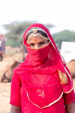 PUSHKAR, RAJASTHAN / INDIA - Kasım 2019: Genç Hintli kız tozdan ve virüslerden korunmak için yüzünü fularla kapattı