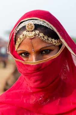 PUSHKAR, RAJASTHAN / INDIA - Kasım 2019: Genç Hintli kız tozdan ve virüslerden korunmak için yüzünü fularla kapattı