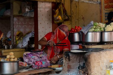 PUSHKAR, RAJASTHAN / INDIA - Kasım 2019: Restoranlarında yemek yiyen turistlere pasta hazırlayan etnik kadın