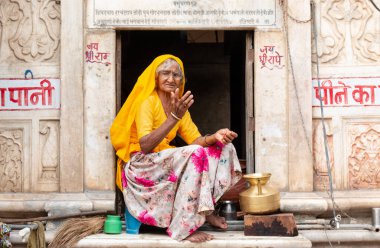 PUSHKAR, RAJASTHAN / INDIA - Kasım 2019: Pencerede oturan yaşlı Hintli kadının portresi