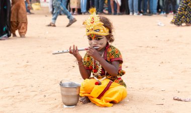 PUSHKAR, RAJASTHAN / INDIA - Kasım 2019: Pushkar Deve Fuarı 'nda Lord Krishna makyajı ve elbise giymiş şirin Hintli türü