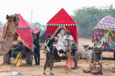PUSHKAR, RAJASTHAN / INDIA - NOVEMBER 2019: Pushkar Fair 'de turistleri para karşılığı çekmek için halk sanatçıları sahne alıyor