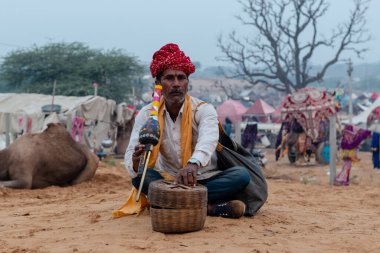 PUSHKAR, RAJASTHAN / INDIA - Yılan Büyücüsü 'nün portresi ve Hint kobra yılanı itme deve fuarında