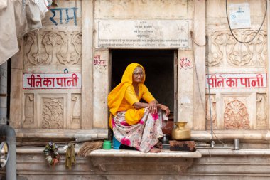 PUSHKAR, RAJASTHAN / INDIA - Kasım 2019: Pencerede oturan yaşlı Hintli kadının portresi