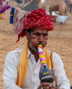 PUSHKAR, RAJASTHAN / INDIA - NOVEMBER 2019: Pushkar Fair 'de turistleri para karşılığı çekmek için halk sanatçıları sahne alıyor