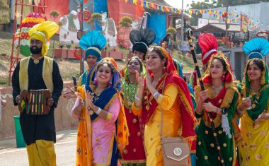 Punjab young girls participating in Baisakhi and Lohri festival in traditional colorful dress and jewellery in Surajkund Craft Fair, Faridabad, Haryana, India clipart