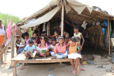 Fakir Hint gecekondu / Köy öğrencileri Noida, Hindistan, Eylül 2019 'da öğretmenleriyle birlikte okuyorlar.