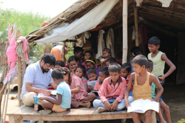 Fakir Hint gecekondu / Köy öğrencileri Noida, Hindistan, Eylül 2019 'da öğretmenleriyle birlikte okuyorlar.