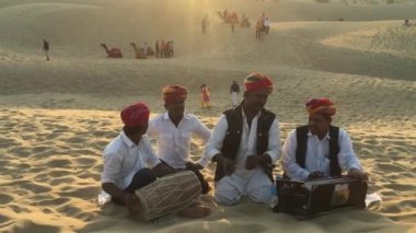 Halk sanatçıları kum tepeleri üzerinde performans sergiliyorlar. Jaisalmer Çölü, Jaisalmer, Rajasthan, Hindistan, Kasım 2019