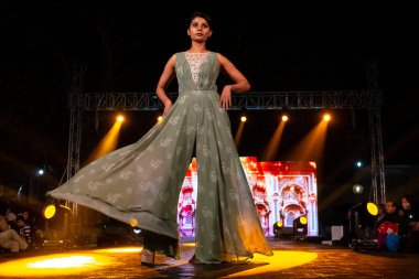 Aralık 2020 'de Yeni Delhi, Hindistan' daki moda fuarında bir model modacı etnik bahar koleksiyonu giyerek podyumda yürüyor.