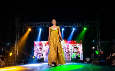 Aralık 2020 'de Yeni Delhi, Hindistan' daki moda fuarında bir model modacı etnik bahar koleksiyonu giyerek podyumda yürüyor.