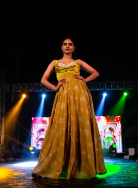 Aralık 2020 'de Yeni Delhi, Hindistan' daki moda fuarında bir model modacı etnik bahar koleksiyonu giyerek podyumda yürüyor.