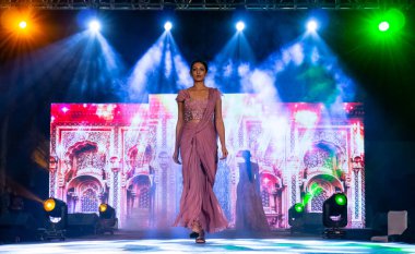 Aralık 2020 'de Yeni Delhi, Hindistan' daki moda fuarında bir model modacı etnik bahar koleksiyonu giyerek podyumda yürüyor.