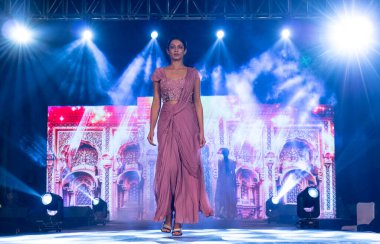 Aralık 2020 'de Yeni Delhi, Hindistan' daki moda fuarında bir model modacı etnik bahar koleksiyonu giyerek podyumda yürüyor.