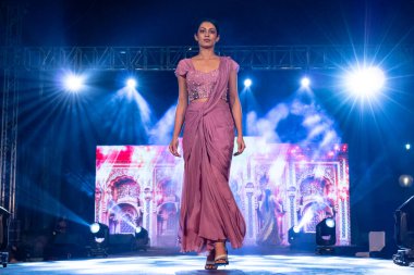 Aralık 2020 'de Yeni Delhi, Hindistan' daki moda fuarında bir model modacı etnik bahar koleksiyonu giyerek podyumda yürüyor.