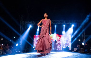 Aralık 2020 'de Yeni Delhi, Hindistan' daki moda fuarında bir model modacı etnik bahar koleksiyonu giyerek podyumda yürüyor.