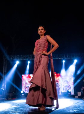 Aralık 2020 'de Yeni Delhi, Hindistan' daki moda fuarında bir model modacı etnik bahar koleksiyonu giyerek podyumda yürüyor.