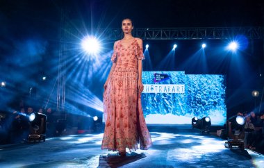 Aralık 2020 'de Yeni Delhi, Hindistan' daki moda fuarında bir model modacı etnik bahar koleksiyonu giyerek podyumda yürüyor.