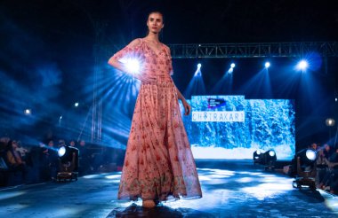 Aralık 2020 'de Yeni Delhi, Hindistan' daki moda fuarında bir model modacı etnik bahar koleksiyonu giyerek podyumda yürüyor.