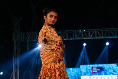 Aralık 2020 'de Yeni Delhi, Hindistan' daki moda fuarında bir model modacı etnik bahar koleksiyonu giyerek podyumda yürüyor.