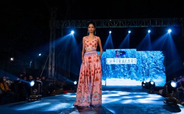 Aralık 2020 'de Yeni Delhi, Hindistan' daki moda fuarında bir model modacı etnik bahar koleksiyonu giyerek podyumda yürüyor.