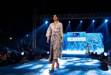 Aralık 2020 'de Yeni Delhi, Hindistan' daki moda fuarında bir model modacı etnik bahar koleksiyonu giyerek podyumda yürüyor.