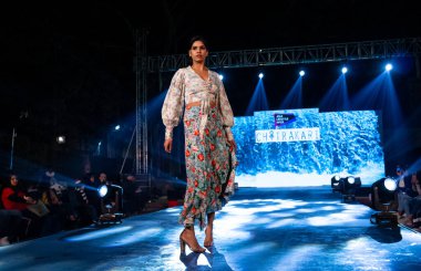 Aralık 2020 'de Yeni Delhi, Hindistan' daki moda fuarında bir model modacı etnik bahar koleksiyonu giyerek podyumda yürüyor.