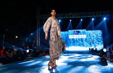 Aralık 2020 'de Yeni Delhi, Hindistan' daki moda fuarında bir model modacı etnik bahar koleksiyonu giyerek podyumda yürüyor.