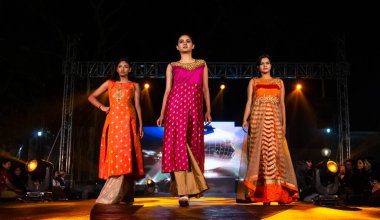 Aralık 2020 'de Yeni Delhi, Hindistan' daki moda fuarında bir model modacı etnik bahar koleksiyonu giyerek podyumda yürüyor.