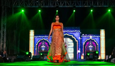 Aralık 2020 'de Yeni Delhi, Hindistan' daki moda fuarında bir model modacı etnik bahar koleksiyonu giyerek podyumda yürüyor.